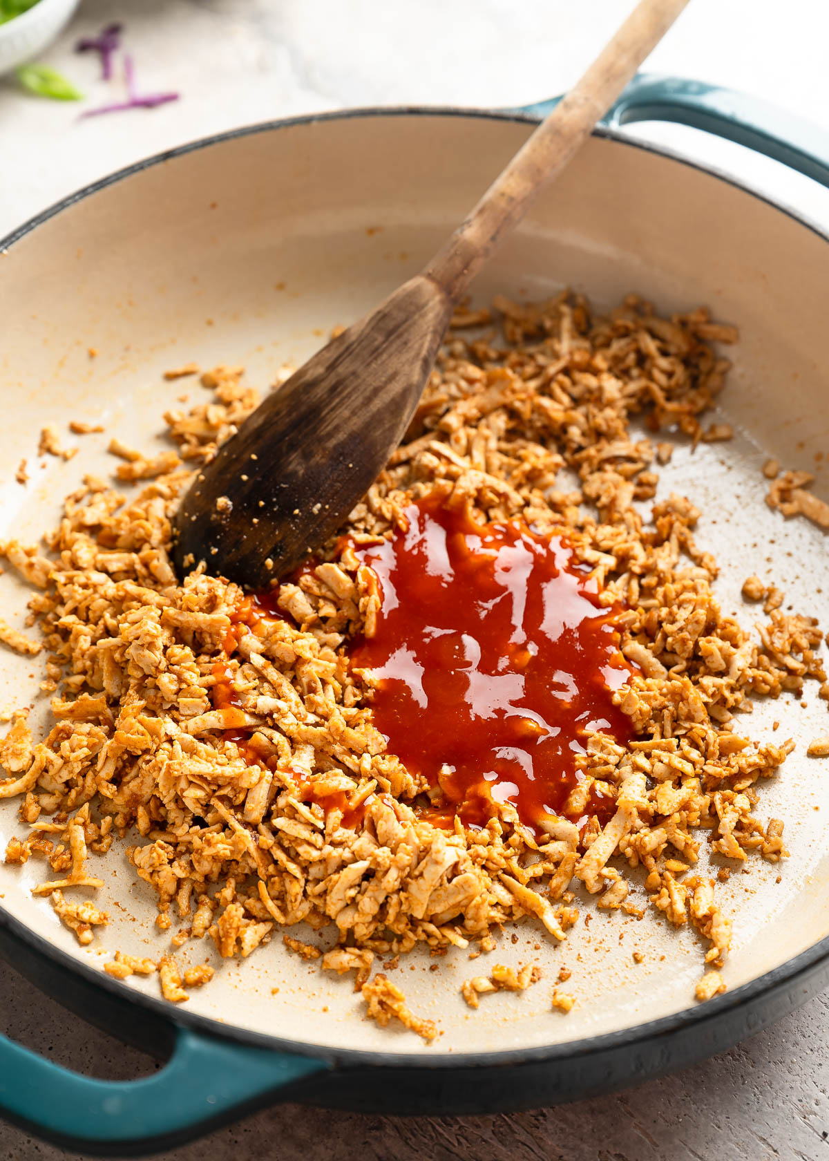 Cooked tofu in a pan along with red sauce.