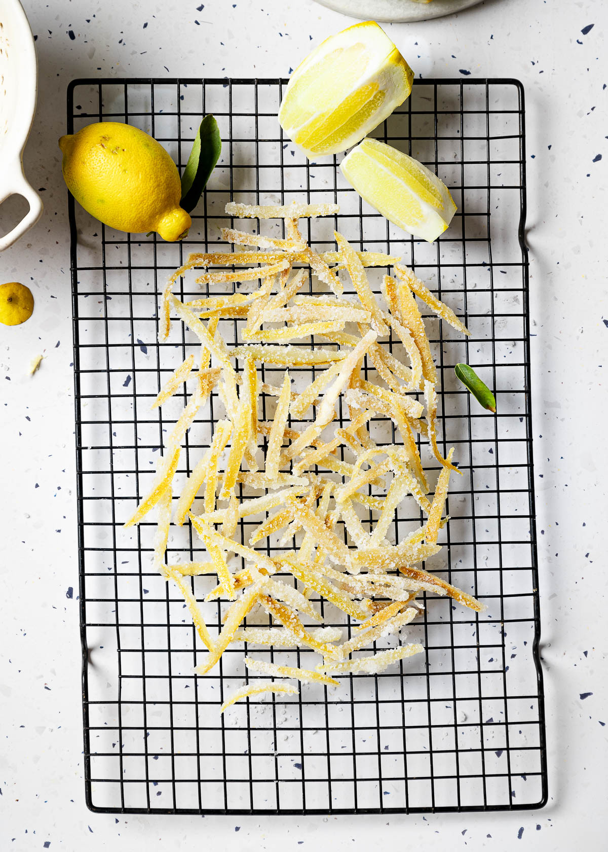 Candied lemon peels on a wire rack.