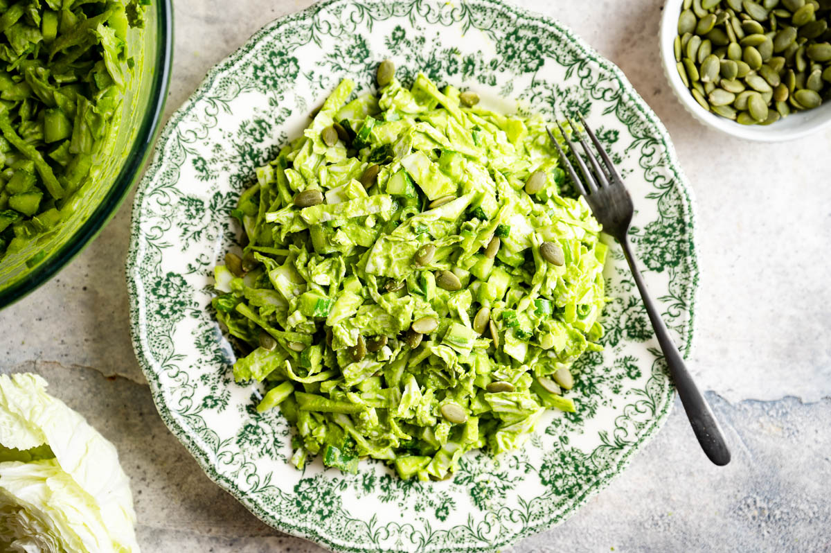 Green goddess salad on an ornate white plate.