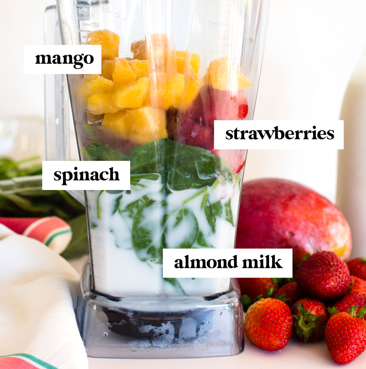 Ingredients in blender to make strawberry mango smoothie.
