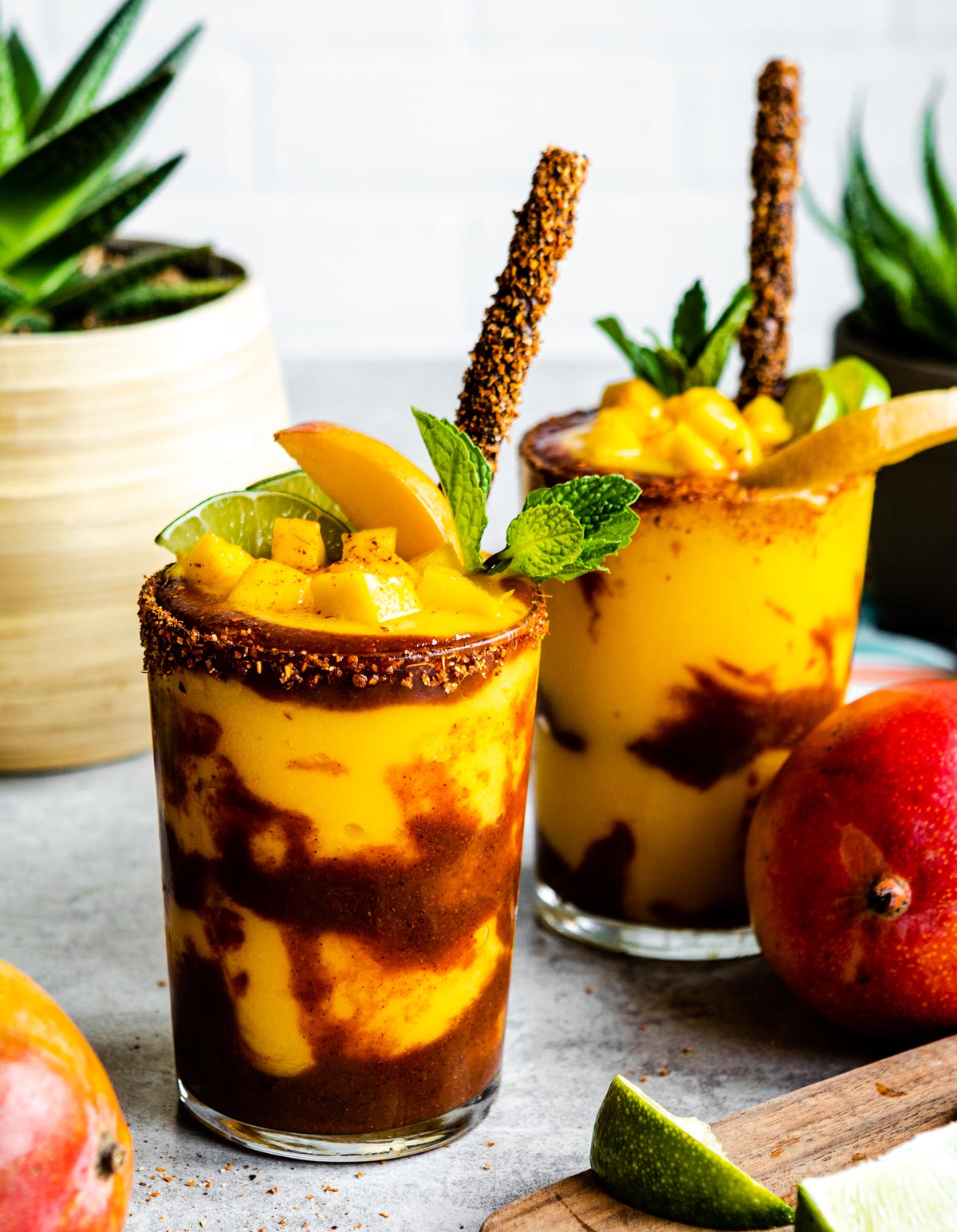 Glass of mangonada with tamarind straw and fresh mint.