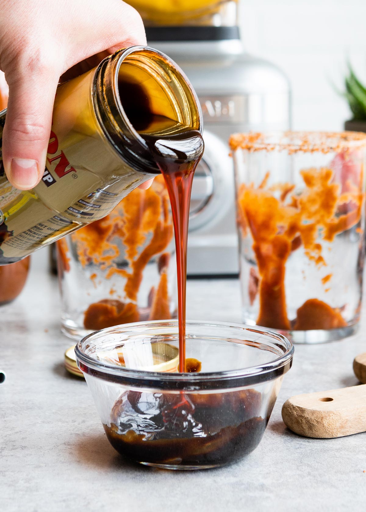 Date syrup being poured into a glass bowl.