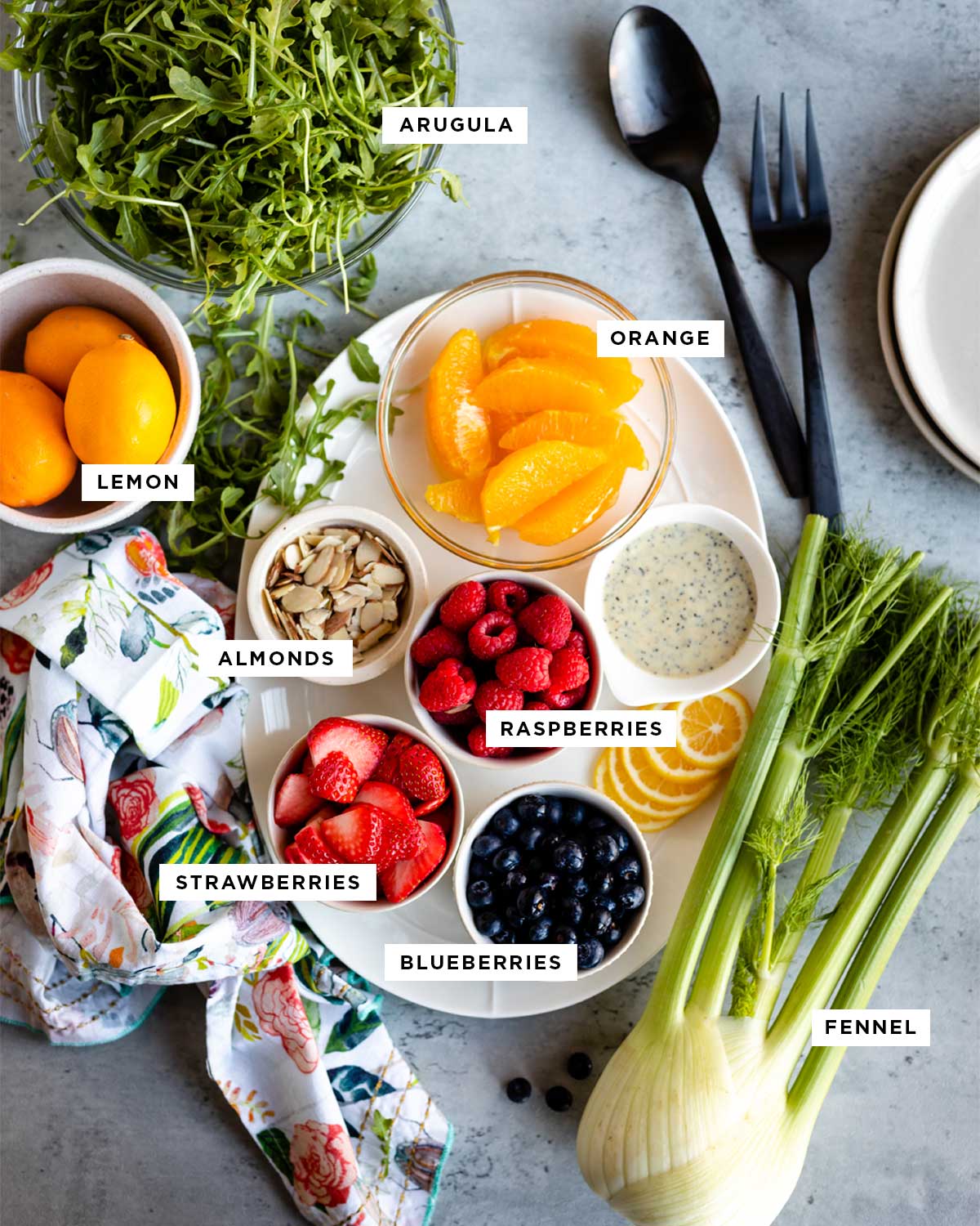 Ingredients for strawberry lemon arugula salad on table.