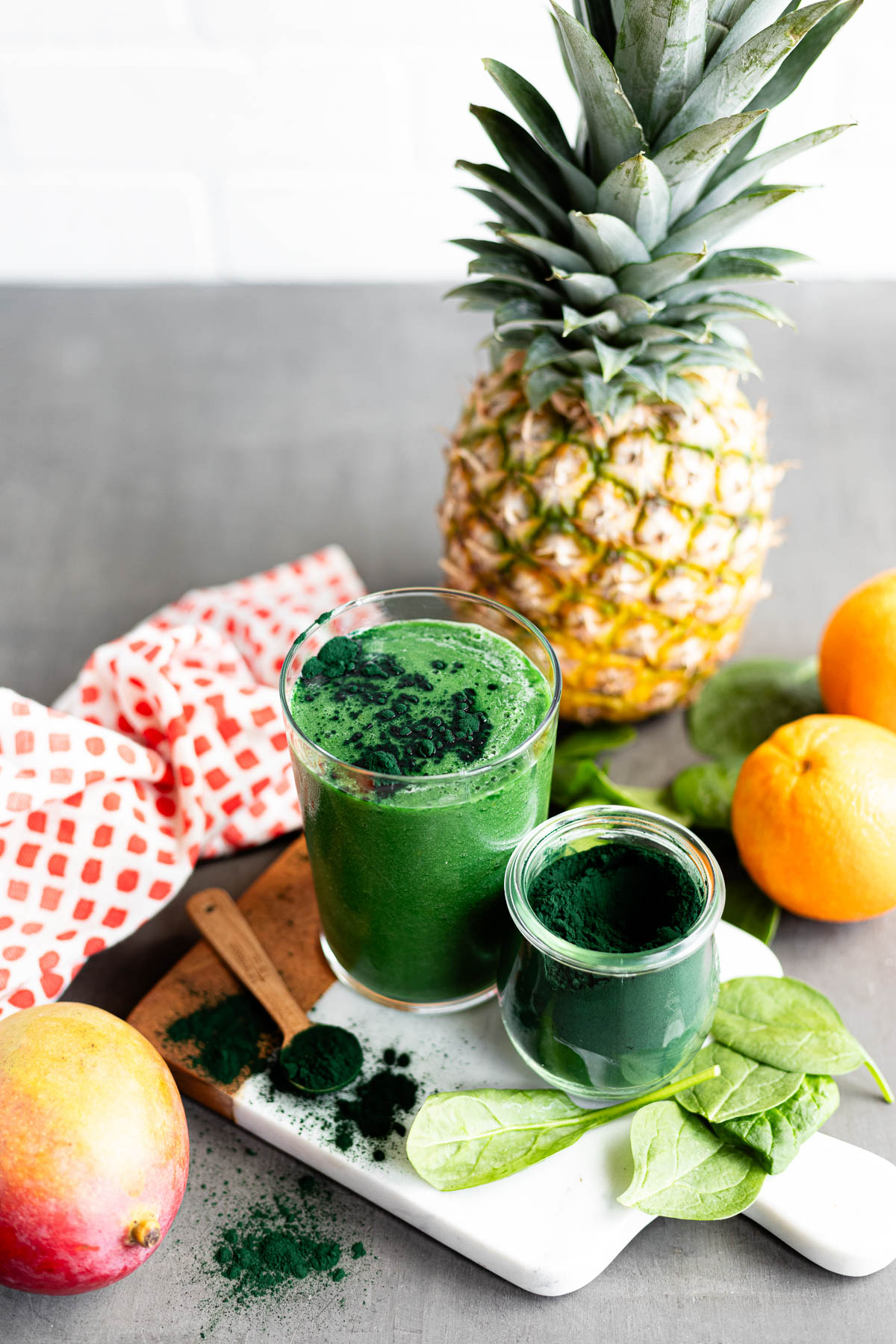 A spirulina smoothie with orange, pineapple, and spinach.
